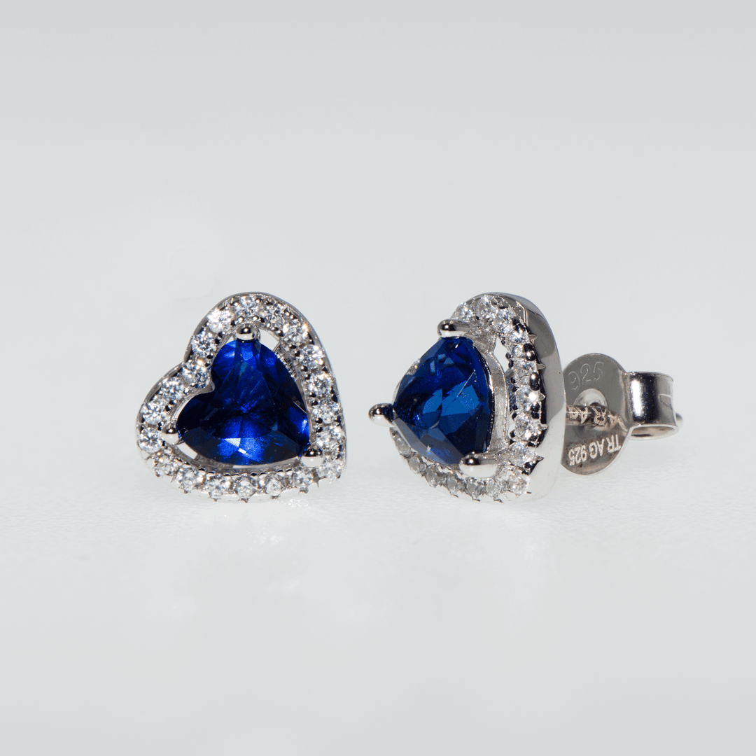 Silberohrringe mit Smaragdblau Ohrsteckern, verziert mit kleinen weißen Zirkonsteinen rund um das Herzsymbol. Tragen Sie die Farben des Frühlings an sich. Ein perfektes Geschenk zum Muttertag.