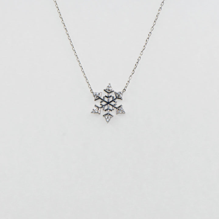 Dieses bezaubernde 925 Silber Collier mit Anhänger ist mit einem detailreichen Schneeflocken-Motiv versehen, das mit funkelnden Zirkonia-Steinen geschmückt ist. Die strahlenden Zirkonia verleihen dem Collier einen eleganten Glanz, der perfekt zu festlichen Anlässen passt. Ein stilvolles Schmuckstück, das winterliche Schönheit und zeitlose Eleganz vereint.