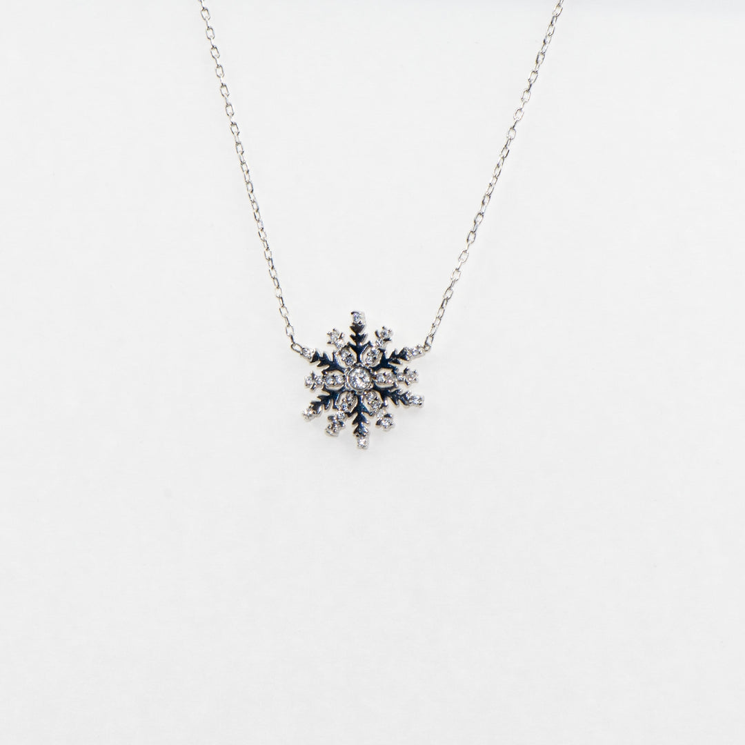 Dieses elegante 925 Silber Collier mit Anhänger ist mit einem funkelnden Schneeflocken-Motiv verziert, das mit strahlenden Zirkonia-Steinen besetzt ist.