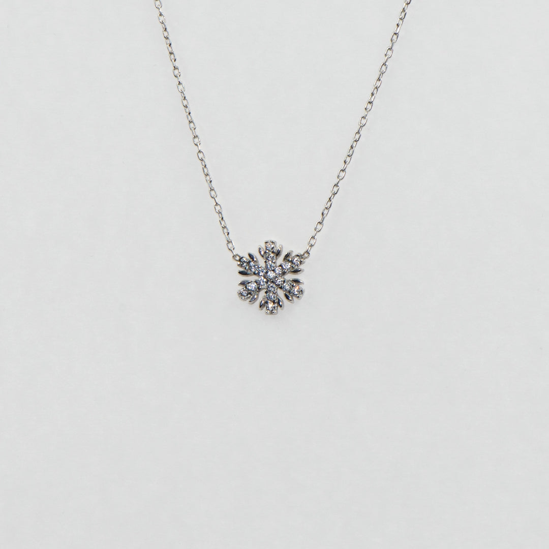 Dieses zierliche 925 Silber Collier mit Anhänger präsentiert ein filigranes Schneeflocken-Motiv, das mit funkelnden weißen Zirkonia-Steinen veredelt ist. Trotz seiner kleinen Größe strahlt es eine elegante Schönheit aus und fängt das Licht auf subtile Weise ein. Dieses Collier ist das perfekte Accessoire für diejenigen, die einen dezenten, aber dennoch glanzvollen Schmuck suchen.