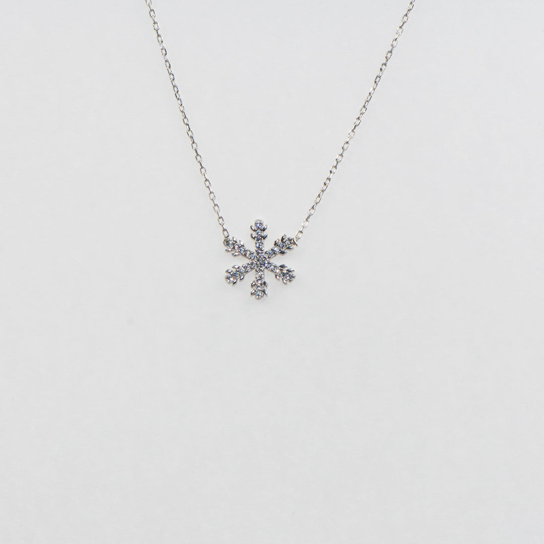 Dieses strahlende 925 Silber Collier mit Anhänger besticht durch ein elegantes Schneeflocken-Motiv, das mit funkelnden weißen Zirkonia-Steinen verziert ist. Die schimmernden Steine fangen das Licht perfekt ein und verleihen diesem Collier eine glanzvolle Ausstrahlung. Mit seiner filigranen Verarbeitung und seinem winterlichen Charme ist es das ideale Accessoire für festliche Anlässe oder als bezauberndes Geschenk.