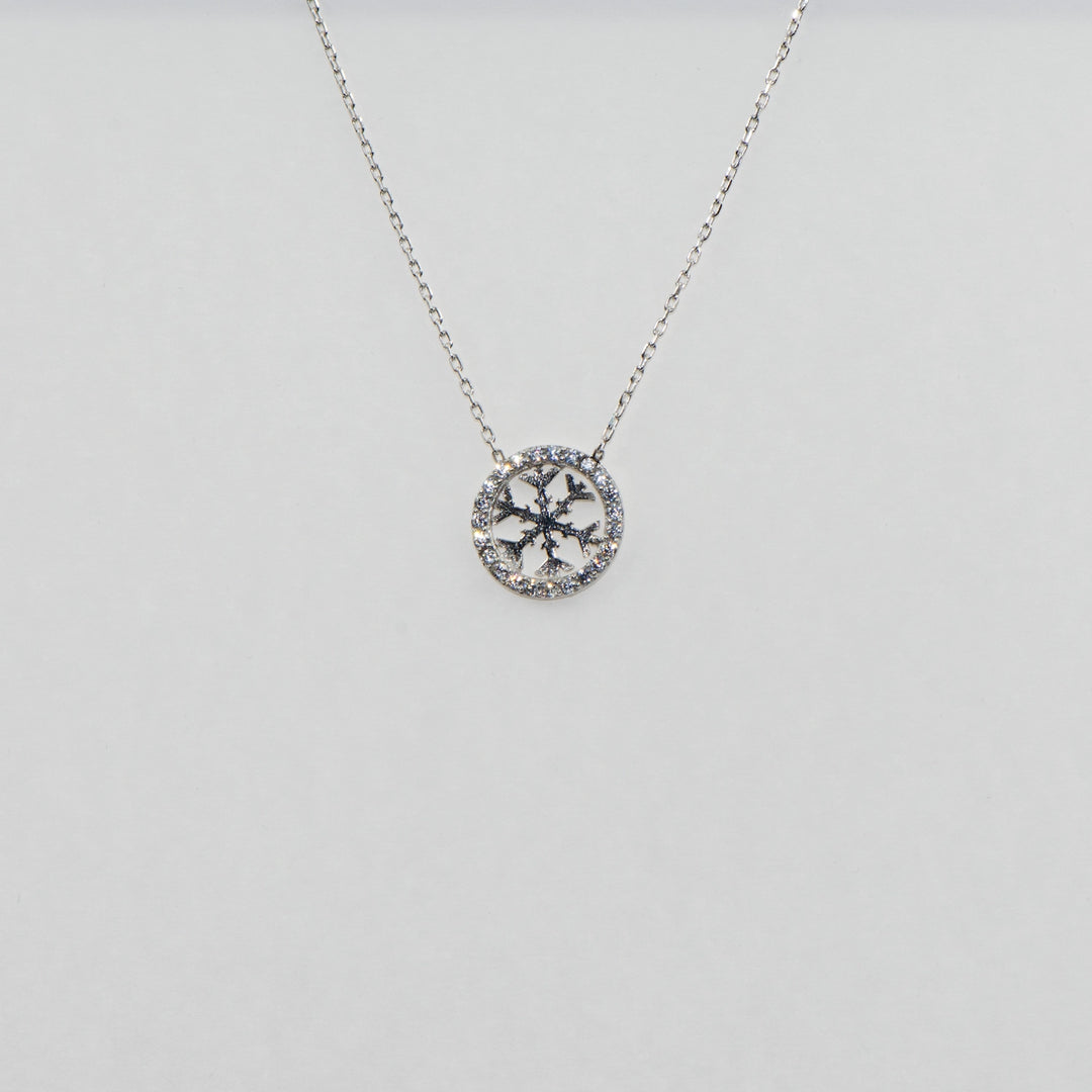 Dieser atemberaubende 925 Silber Anhänger in runder Form ist mit einem funkelnden Schneeflocken-Motiv verziert, das mit glänzenden Zirkonia-Steinen besetzt ist. Das detailreiche Design und die edle Verarbeitung machen diesen Silberanhänger zu einem eleganten Schmuckstück, das perfekt für festliche Anlässe oder als besonderes Geschenk geeignet ist.