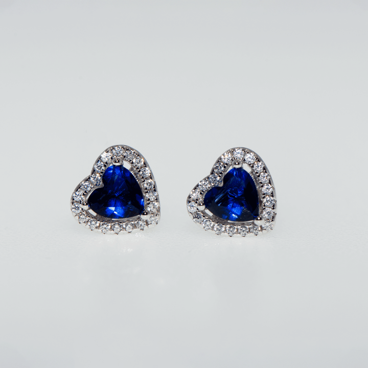 Silberohrringe mit Smaragdblau Ohrsteckern, verziert mit kleinen weißen Zirkonsteinen rund um das Herzsymbol. Tragen Sie die Farben des Frühlings an sich. Ein perfektes Geschenk zum Muttertag. 