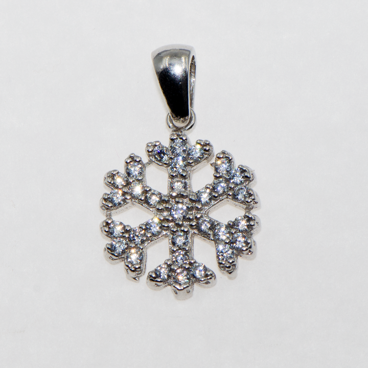 Klassischer Schneeflocken-Anhänger von Schmucktime. 925er Sterlingsilber, verziert mit weißen Zirkonsteinen. Einer der Klassiker, der in Ihrem Schmuckkästchen fehlen sollte. Es ist auch eine besondere Geschenkidee für Ihre Lieben.