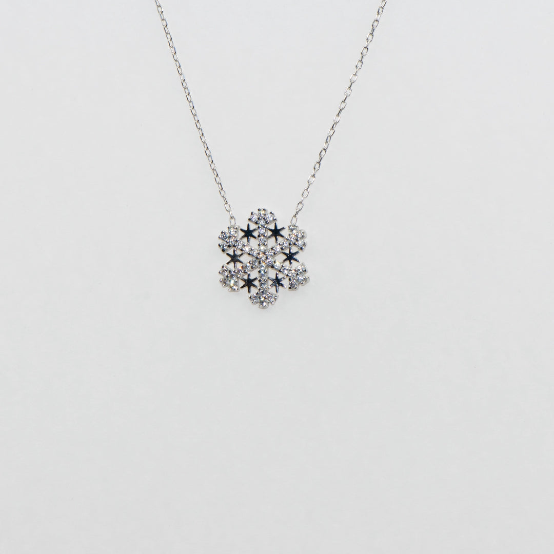 Dieses einzigartige 925 Silber Collier mit Anhänger kombiniert ein funkelndes Schneeflocken-Motiv mit einem zarten Stern, beide geschmückt mit strahlenden Zirkonia-Steinen. Die feine Verarbeitung und das faszinierende Design machen dieses Collier zu einem besonderen Blickfang. Ideal für festliche Anlässe oder als bezauberndes Geschenk, vereint es die Magie des Winters mit zeitloser Eleganz.