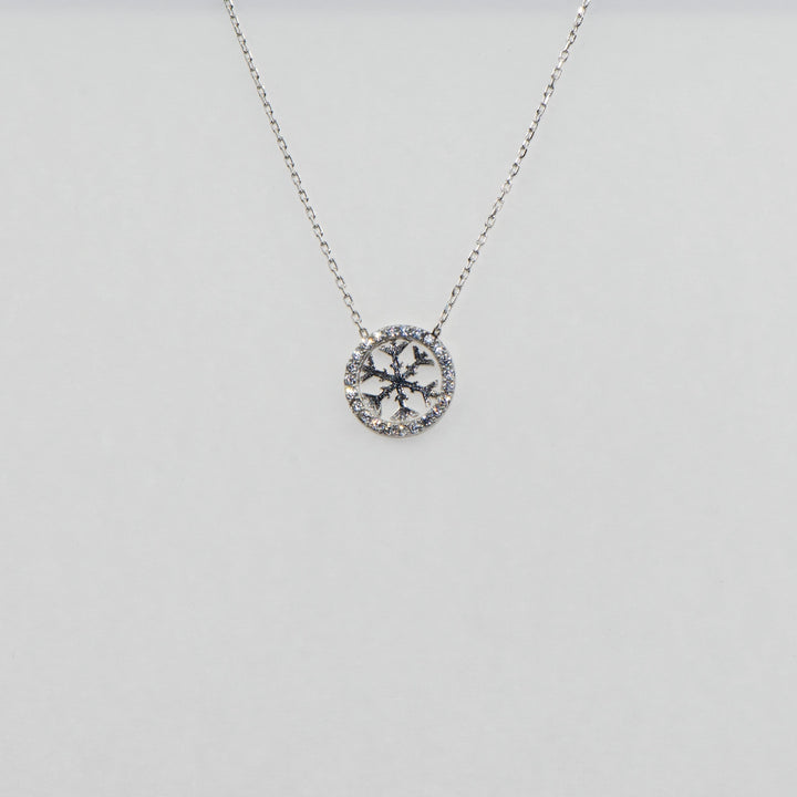 Dieser atemberaubende 925 Silber Anhänger in runder Form ist mit einem funkelnden Schneeflocken-Motiv verziert, das mit glänzenden Zirkonia-Steinen besetzt ist. Das detailreiche Design und die edle Verarbeitung machen diesen Silberanhänger zu einem eleganten Schmuckstück, das perfekt für festliche Anlässe oder als besonderes Geschenk geeignet ist.