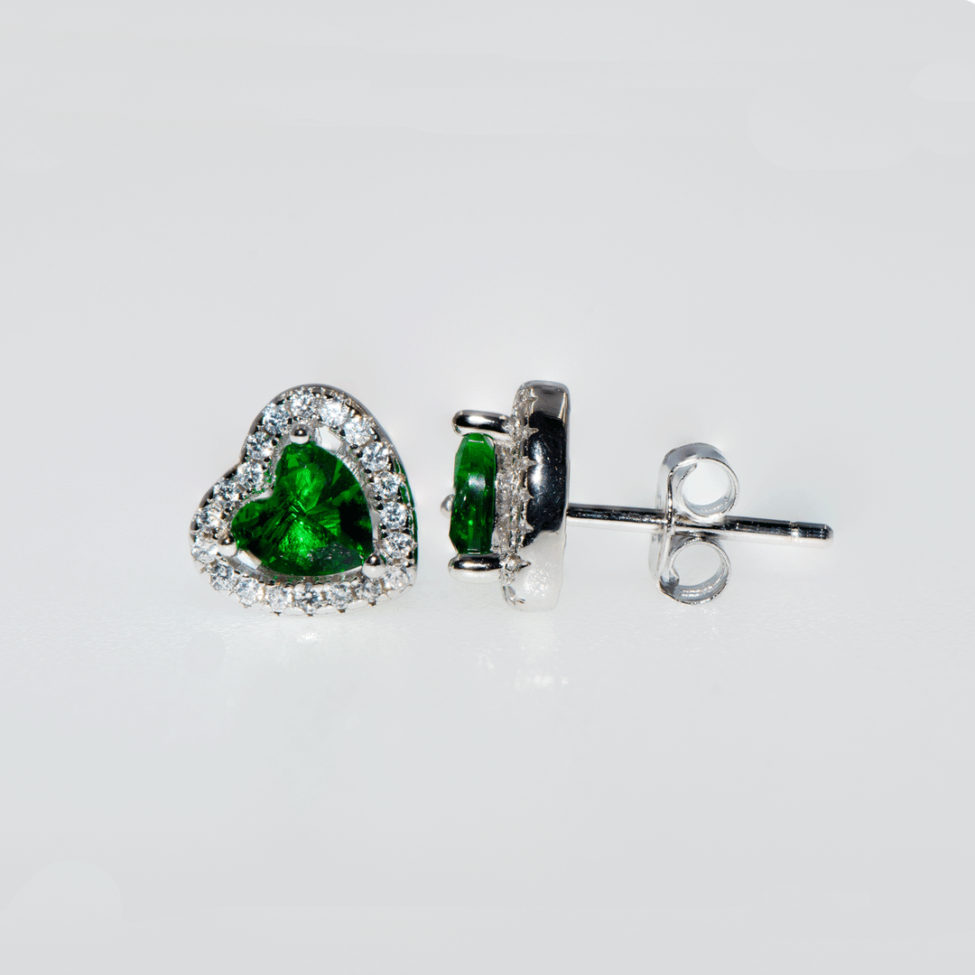 Grüne Smaragd-Herz-Ohrringe aus 925er Silber, umgeben von funkelnden Zirkonsteinen. Die Ohrringe in mittlerer Größe vereinen Eleganz und Stil. Grüne Smaragd-Ohrringe, Zirkon-Ohrringe, 925er Silber-Ohrringe.