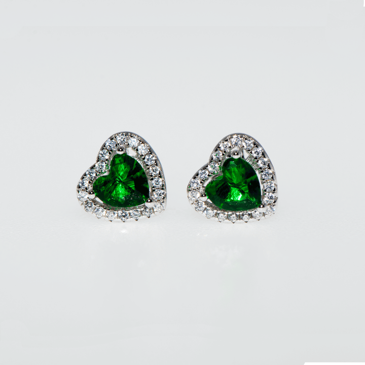 Grüne Smaragd-Herz-Ohrringe aus 925er Silber, umgeben von funkelnden Zirkonsteinen. Die Ohrringe in mittlerer Größe vereinen Eleganz und Stil. Grüne Smaragd-Ohrringe, Zirkon-Ohrringe, 925er Silber-Ohrringe.