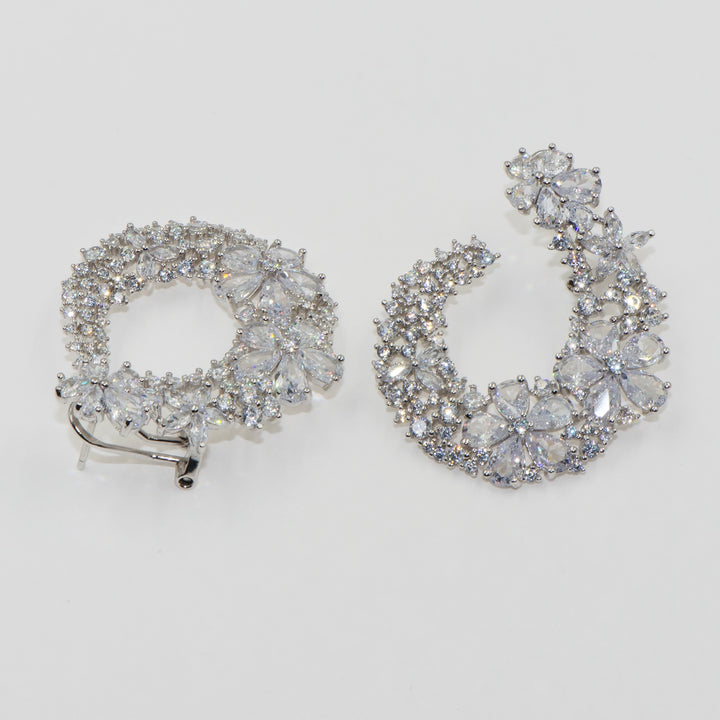 Diese luxuriösen 925er Silber Ohrringe mit Blumenmuster und funkelnden Zirkonsteinen vereinen Stil und Eleganz. Das florale Design verleiht einen glamourösen Touch, ideal für besondere Anlässe. Der praktische Klappverschluss sorgt für einfaches und sicheres Tragen. Perfekt für Frauen, die Eleganz und Komfort suchen, und auch ideal als Geschenk.