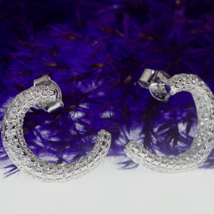 Entdecken Sie unsere eleganten Ohrstecker aus 925er Sterling Silber, verziert mit funkelnden weißen Zirkonsteinen. Diese Ohrringe sind die perfekte Wahl für jeden Anlass und bieten einen zeitlosen Look, der zu jedem Outfit passt.